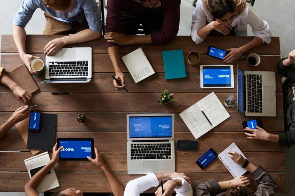 An overhead view of people and laptops around a table
